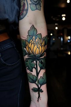 a person with a tattoo on their arm has a yellow and green flower in it