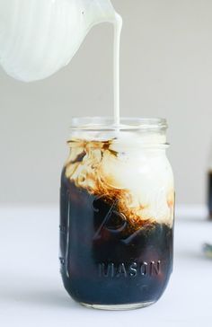 a mason jar filled with liquid sitting on top of a table