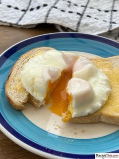 an egg and cheese sandwich is on a blue and white plate with a napkin next to it