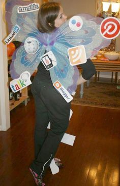 a woman dressed as a butterfly with social media stickers on her wings