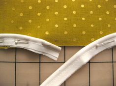 two pieces of fabric are laying next to each other on a tile floor with yellow and white polka dots