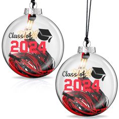 two glass ornament ornaments with graduation caps and ribbons in red, black and white