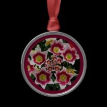 an ornament shaped like a flower on a black background with pink and yellow flowers