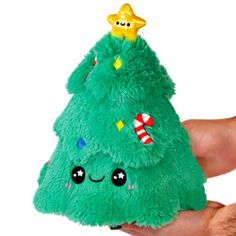 a hand holding a green stuffed christmas tree