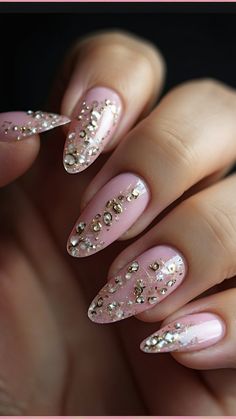 a woman's hand with some pink and gold nail polishes on her nails