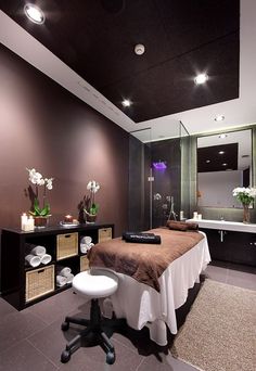 a spa room with a bed, sink and mirror