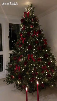 a decorated christmas tree with two red candles