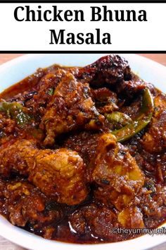 chicken bhuna masala in a white bowl with green peppers on the side