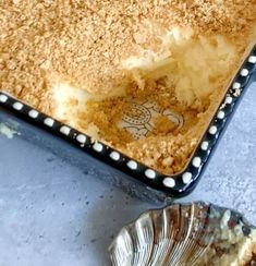 a pie sitting on top of a metal pan next to a silver bowl filled with cake