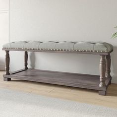 a wooden bench sitting in front of a plant on top of a hard wood floor