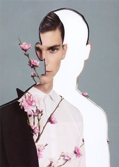 a man in a white shirt and black jacket with pink flowers on his head is standing next to a woman's face