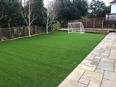 a backyard with artificial grass and a soccer goal