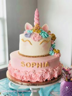 there is a pink cake with a unicorn on it