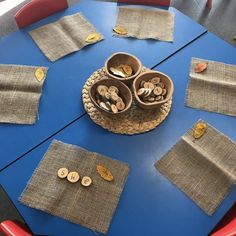 a blue table topped with lots of buttons and burlap placemats on top of it