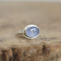 Soft, natural, blue Chalcedony is absolutely elusive and breathtaking here in this minimal, East-West Oval, .925 Sterling Silver Ring. If you love blue chalcedony, the quality here is lovely. Beautiful, Soft blue chalcedony is highlighted by the modern sterling silver design. All traditional Silversmithing techniques done in our Baltimore, MD studio Blue Chalcedony AA - 10x14mm Ring Top measures 13x17mm All .925 Sterling Silver Chalcedony is a nurturing stone that promotes brotherhood and good will. It absorbs negative energy. It brings the mind, body, emotions and spirit into harmony. At Linda Blackbourn Jewelry, I've tried my best to describe everything as accurately as possible -- in words and photos. Gemstones vary, of course, as do computer monitor screens, so there may be minor discr Modern Chalcedony Jewelry With Polished Finish, Blue Moonstone Rings With Natural Stones, Modern Chalcedony Rings For Gift, Fine Jewelry Chalcedony Gemstone Rings, Handmade Moonstone Ring For Anniversary, Blue Moonstone Cabochon Ring, Blue Moonstone Ring For Gift, Minimalist Style, Anniversary Chalcedony Ring With Polished Finish, Modern Blue Moonstone Gemstone Ring