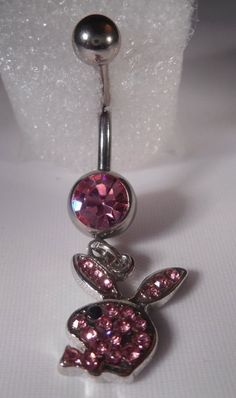 a pink crystal bunny belly button ring on a white background with glittery crystals in the center