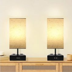 two lamps sitting on top of a wooden table