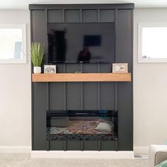 a living room with a fireplace and tv mounted on the wall above it's mantle