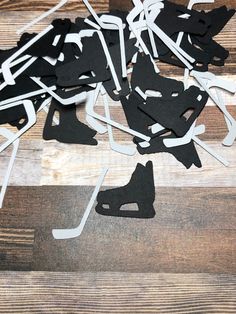 black and white paper cutouts on wooden floor next to each other with scissors in them