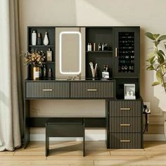 a black vanity with drawers, mirror and stool next to a potted plant on the floor