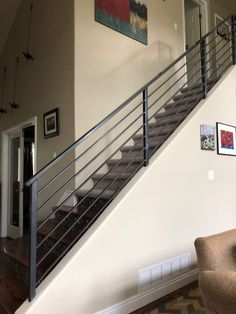 a living room filled with furniture and a metal stair case in front of a door