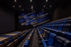 an empty theater with rows of blue seats