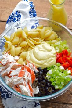 a glass bowl filled with pasta salad and dressing