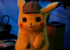 a pikachu stuffed animal with a hat on it's head sitting in front of a table