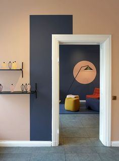 an open door leading to a living room with blue walls and yellow furniture on the floor