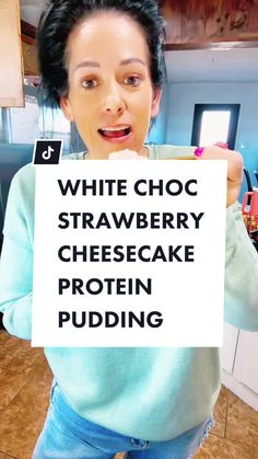 a woman holding up a sign that says white choc strawberry cheesecake protein pudding