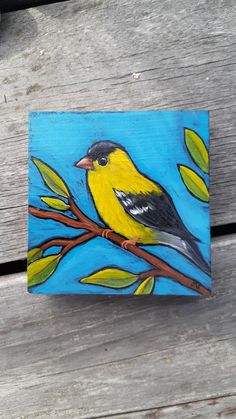 a painting of a yellow bird perched on a tree branch with blue sky in the background