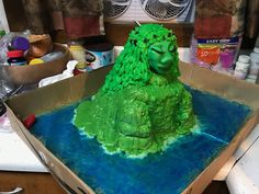 there is a cake in the shape of a green monster sitting on top of a box