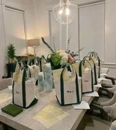 several bags sitting on top of a table with flowers in the middle and other items around them