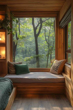 a bedroom with a window seat next to a bed and wooden flooring, surrounded by greenery