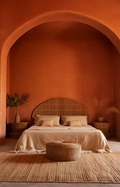 a bedroom with an orange wall and bed in the middle, surrounded by wicker furniture