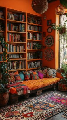 an orange room with lots of bookshelves and colorful rugs on the floor