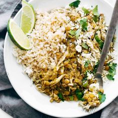 a white plate topped with rice, beans and cilantro