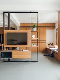 a living room filled with furniture and a flat screen tv on top of a wooden wall