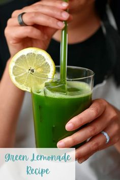 a person holding a glass with a green drink