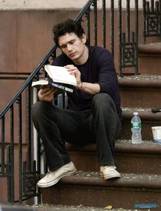 a man sitting on the steps reading a book