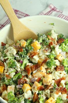 a bowl filled with broccoli and cheese on top of a checkered table cloth