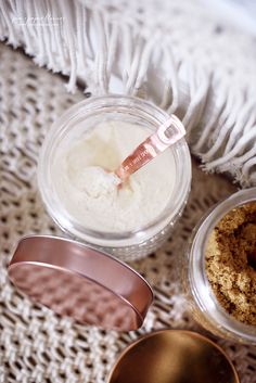 three small bowls with food in them sitting on a white blanket next to two measuring spoons