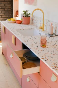 a kitchen with pink cabinets and white counter tops