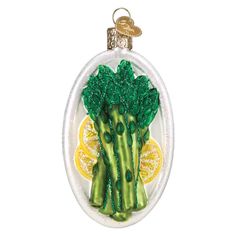 a glass ornament with broccoli and lemon slices on it's side