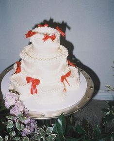 a three tiered cake with red bows on it