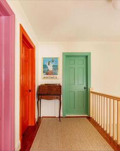 an entryway with two doors and a painting on the wall next to a table