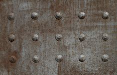 an old metal surface with holes and rivets