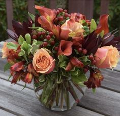 a vase filled with orange flowers on top of a wooden table