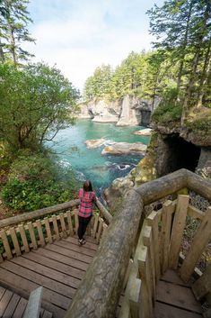 a woman is standing at the top of a wooden staircase looking out over a body of water