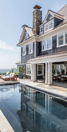 a large house with a pool in front of it and an ocean view behind it